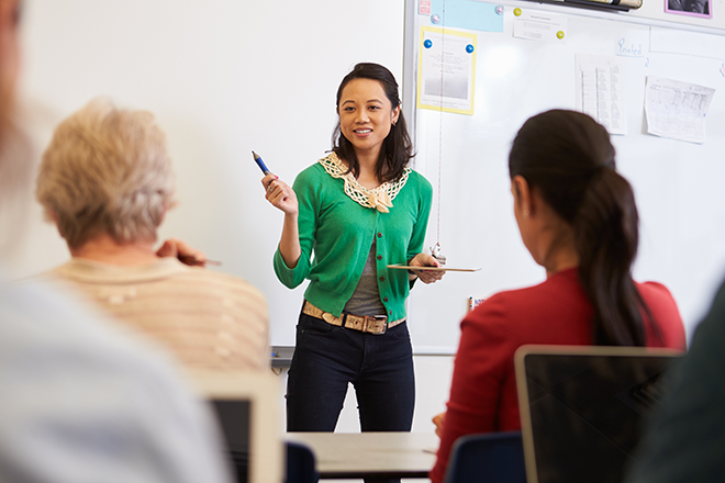 Teacher in front of students at an adult education class.